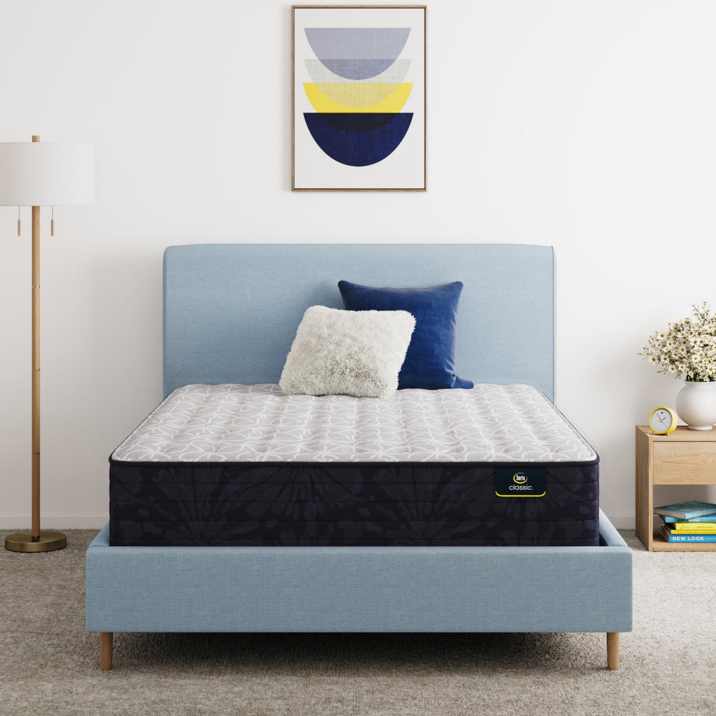 Serta Classic Clarks Hill 13" mattress sitting in a blue bed frame with 2 pillows on top of it.