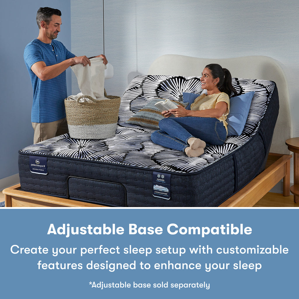 Man standing to the left of and a woman laying on a Perfect Sleeper X Quilted Hybrid Excelled Plush Mattress sitting in an adjustable base frame || feel: Plush || level: Level 2