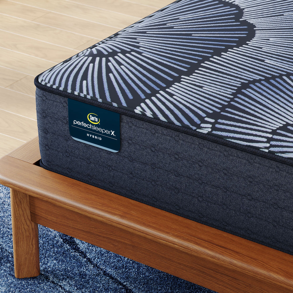 Corner of Perfect Sleeper X Hybrid Kendall Medium Mattress sitting in a brown bedframe || feel: medium || level: Level 1