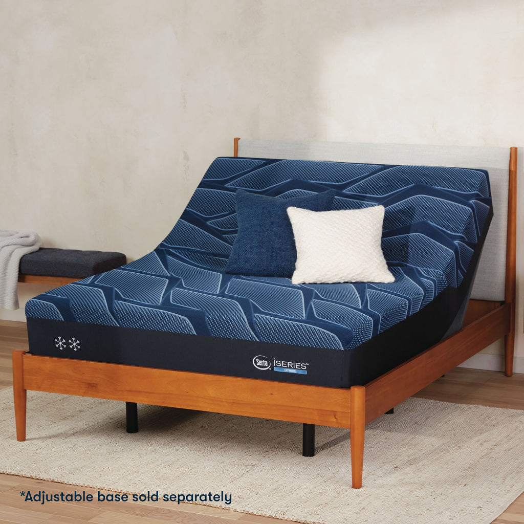 Serta iSeries firm blue mattress sitting in a adjustable frame, in a brown bed with a blue and white pillow on top||feel: firm||level: enhanced