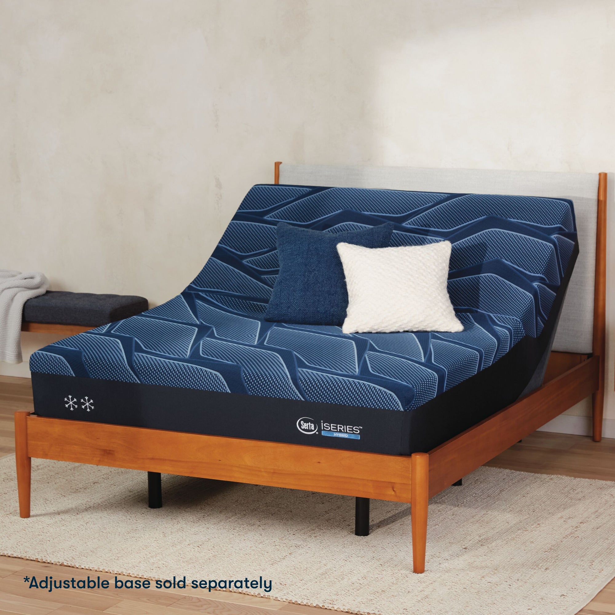 Serta iSeries firm blue mattress sitting in a adjustable frame, in a brown bed with a blue and white pillow on top||feel: firm||level: enhanced