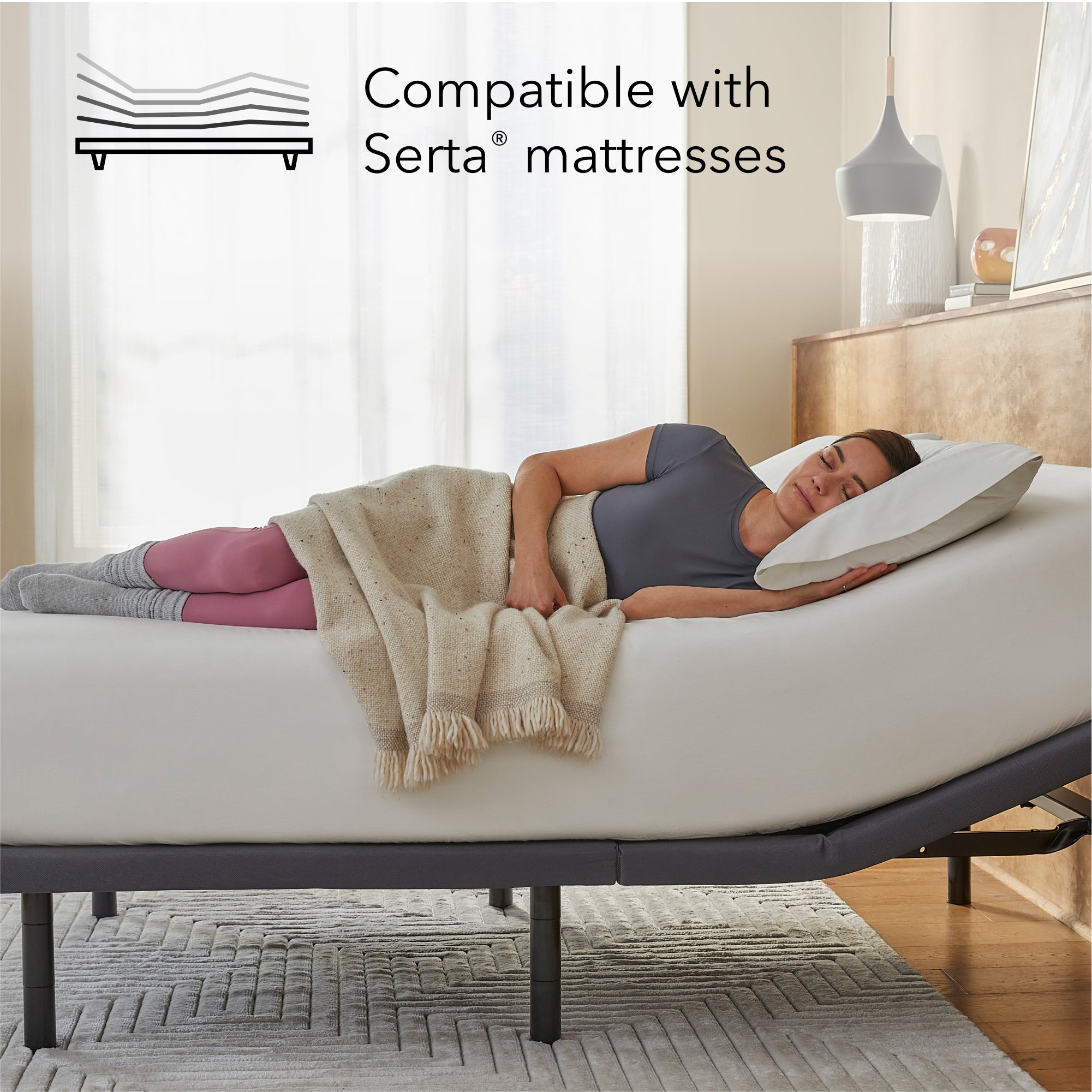 Woman laying asleep on a white mattress sitting on a Baselogic Gold Adjustable Base