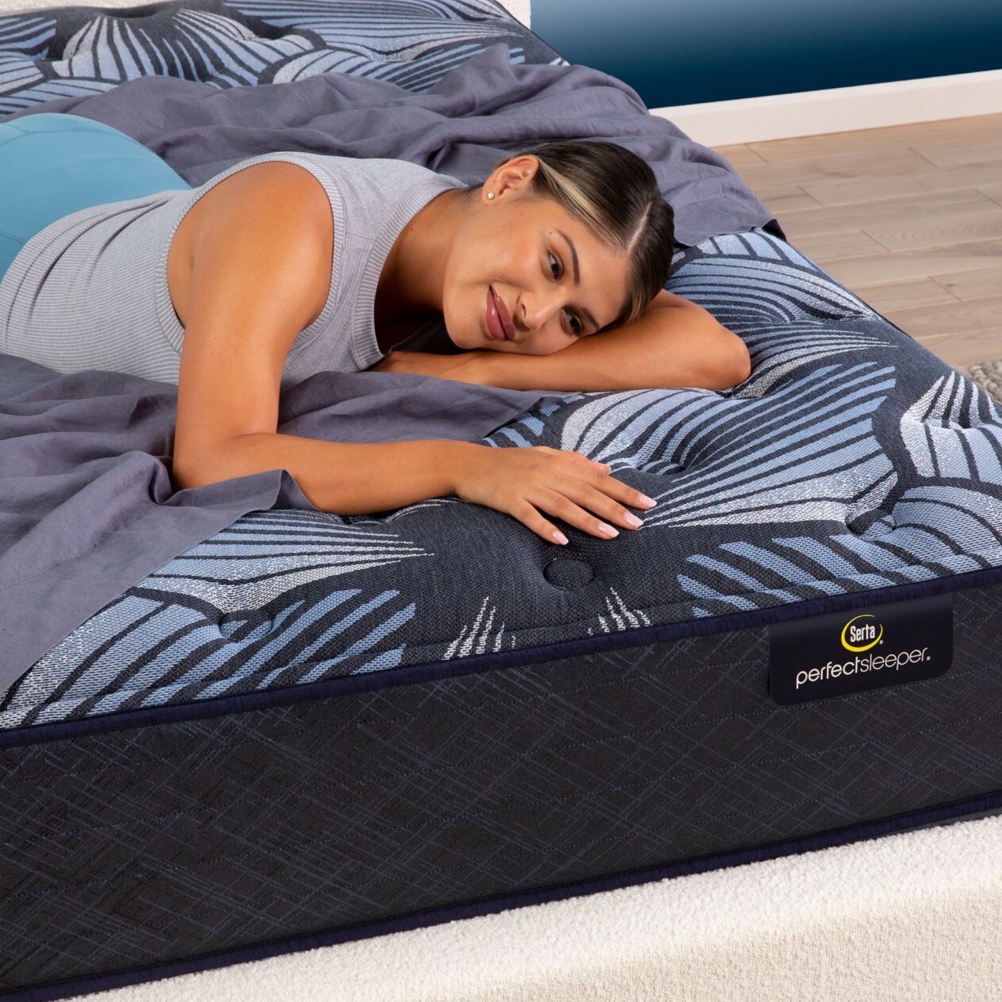 A woman laying in a bedroom on the Serta Perfect Sleeper Sleep Excellence mattress | feel: plush