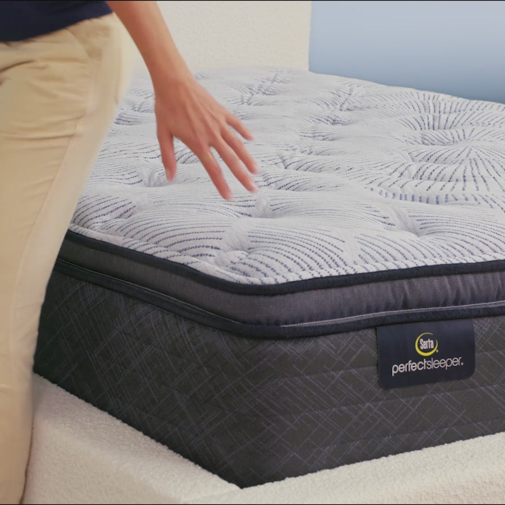Person sitting on bed to show firmness level of Serta Perfect Sleeper plush pillow top mattress||feel: plush pillow top||level: enhanced